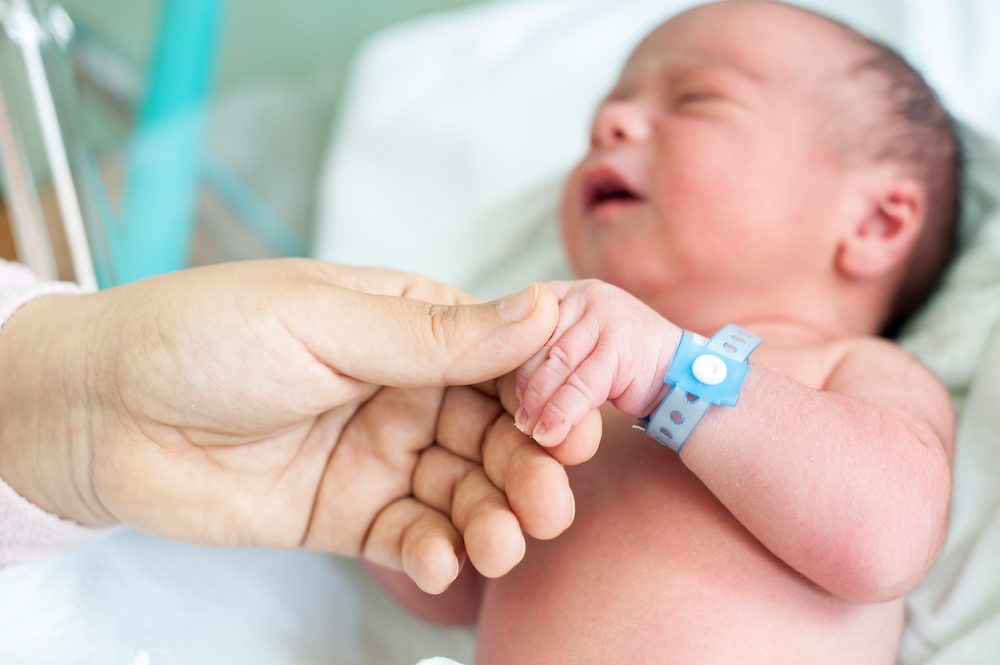 Newborn baby in hospital with identification bracelet tag name